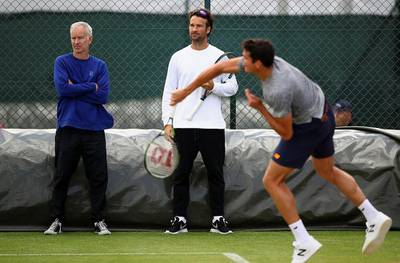 Milos Raonic of Canada is watched by his coaches John McEnroe and Carlos Moya during a practice session prior to the Wimbledon Lawn Tennis Championships at the All England Lawn Tennis and Croquet Club on June 26, 2016 in London, England.  Clive Brunskill/Getty Images