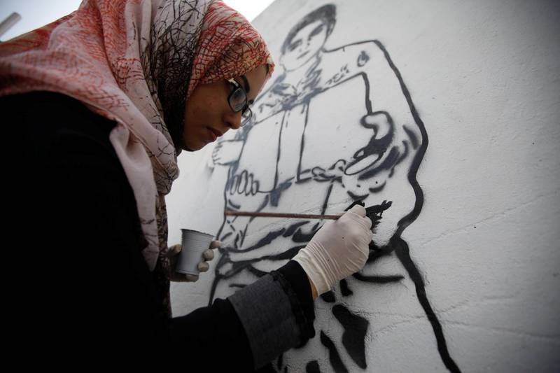 Haifa Subay says her paintings depict the suffering of women and children in Yemen's three-year civil war. Mohamed Al Sayaghi / Reuters