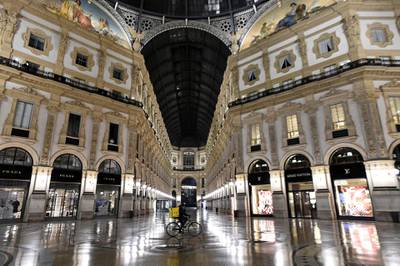 A person cycles past an empty Galleria Vittorio Emanuele II as the region of Lombardy imposes a curfew after being hit by a surge of Covid-19 infections, in Milan, Italy. Reuters