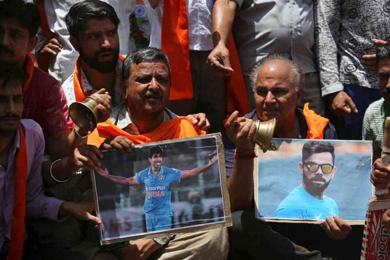 Indian cricket fans holding photographs of captain Virat Kohli, right and Jasprit Bumrah pray for the victory before the match in Jammu, India. AP Photo