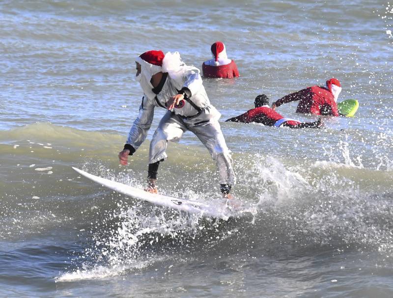 Surfer Corey Howell wears a combination spaceman Santa suit in a nod to Cocoa Beach, where many US rocket launches take place. Florida Today / AP