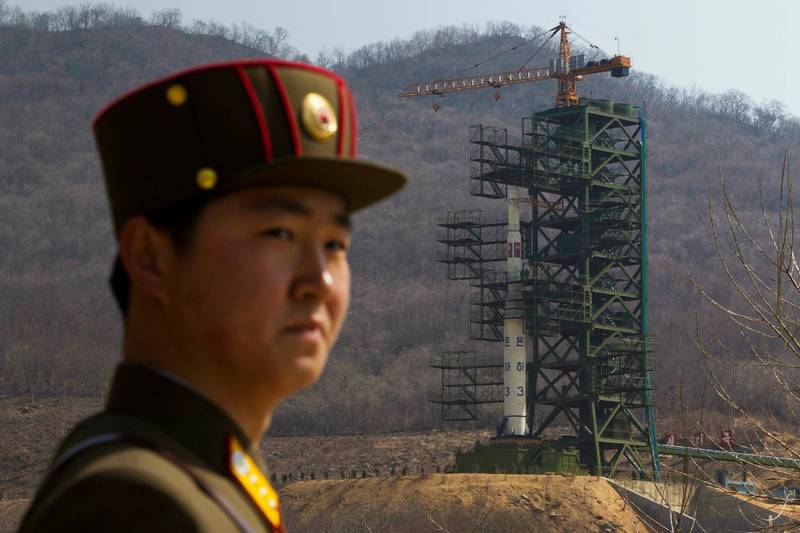 FILE - In this April 8, 2012, file photo, a soldier stands in front of the Unha-3 rocket at a launching site in Tongchang-ri, North Korea. North Korea is reportedly restoring facilities at its long-range rocket launch site that it had dismantled as part of disarmament steps last year. A major South Korean newspaper reports that the country's spy service gave such an assessment to lawmakers in a private briefing on Tuesday. (AP Photo/David Guttenfelder, File)
