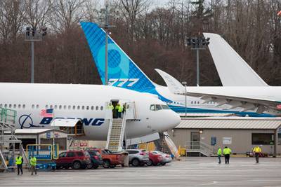 Boeing workers are pictured near a 777X airplane during a first flight event, which had to be rescheduled due to weather, at Paine Field in Everett, Washington on January 24, 2020. AFP