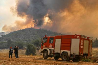A fire engine is parked in front of a blaze raging in New Peramos, near Athens. AFP