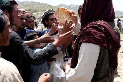 Afghan men receive bread. Reuters