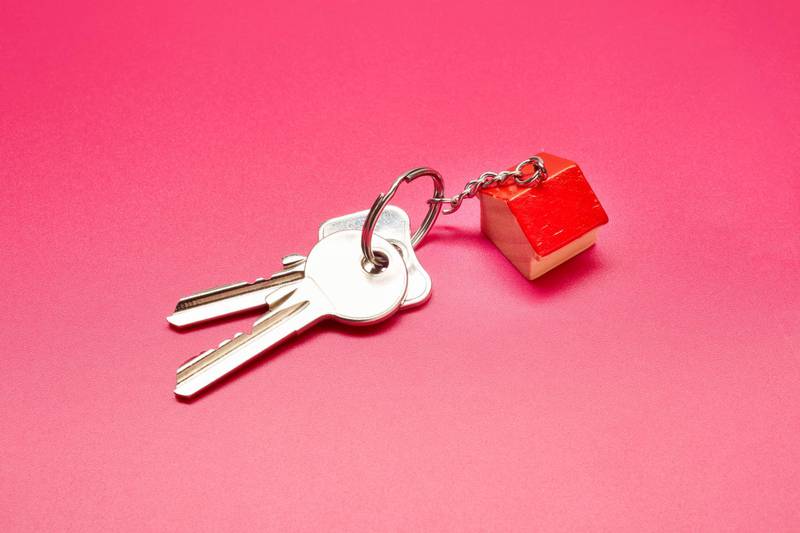 High angle view of keyring with a small house on colored background