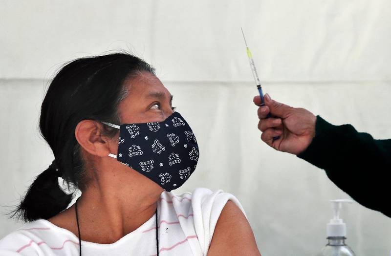 FILE - In this Feb. 15, 2021 file photo, a woman eyes a syringe as she prepares to be inoculated with a dose of the AstraZeneca vaccine against COVID-19 in the Magdalena Contreras area of Mexico City, during a vaccination campaign for the elderly. As Mexico approaches 200,000 in officially test-confirmed deaths from COVID-19, the real death toll is probably higher due to the countryâ€™s extremely low rate of testing. (AP Photo/Marco Ugarte, File)