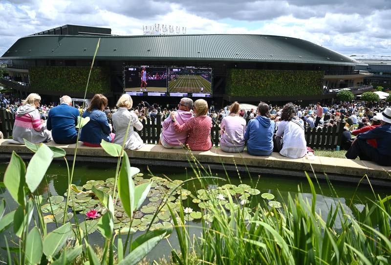 Spectators watch first round tennis matches on a screen outside Court No 1 at the Wimbledon Championships in London, England. EPA