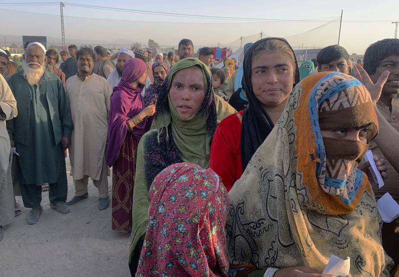Afghan families gather to receive food on the outskirts of Chaman, a border town in Pakistan's southwestern Baluchistan province.  Dozens of Afghan families have crossed into Pakistan. Photo: AP
