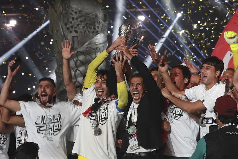 Iraqi national football team players lift the trophy as they celebrate at the stadium in Basra. AP