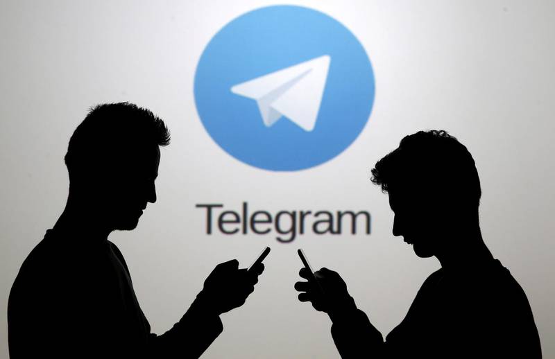 FILE PHOTO: Men pose with smartphones in front of a screen showing the Telegram logo in this picture illustration November 18, 2015. REUTERS/Dado Ruvic/File Photo