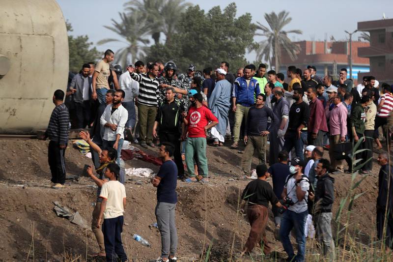 People gather at the site where train carriages derailed in Qalioubia province, north of Cairo, Egypt. Reuters
