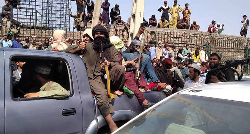 Taliban fighters travel along a street in Jalalabad province.
