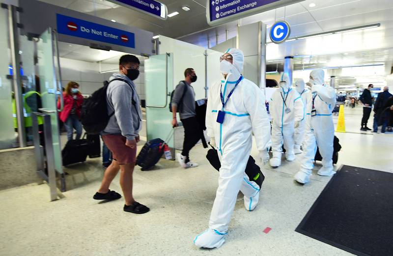 Air China crew members arrive at Los Angeles International Airport in hazmat suits after the county reported its first case of the Omicron variant. AFP
