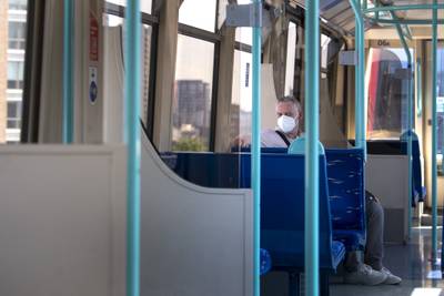 A man wearing a face mask on an almost empty train in East London. PA