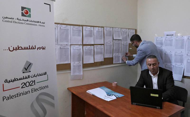 Employees of the Palestinian Central Elections Commission display electoral lists ahead of the upcoming general elections, at the commission's district offices in the city of Hebron in the Israeli-occupied West Bank, on April 6, 2021. Palestinian legislative elections are scheduled for May 22, with a presidential vote to follow on July 31. / AFP / HAZEM BADER
