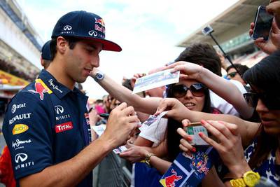 Daniel Ricciardo signs autographs for fans in the pit lane ahead of the Spanish Grand Prix. Clive Mason / Getty
