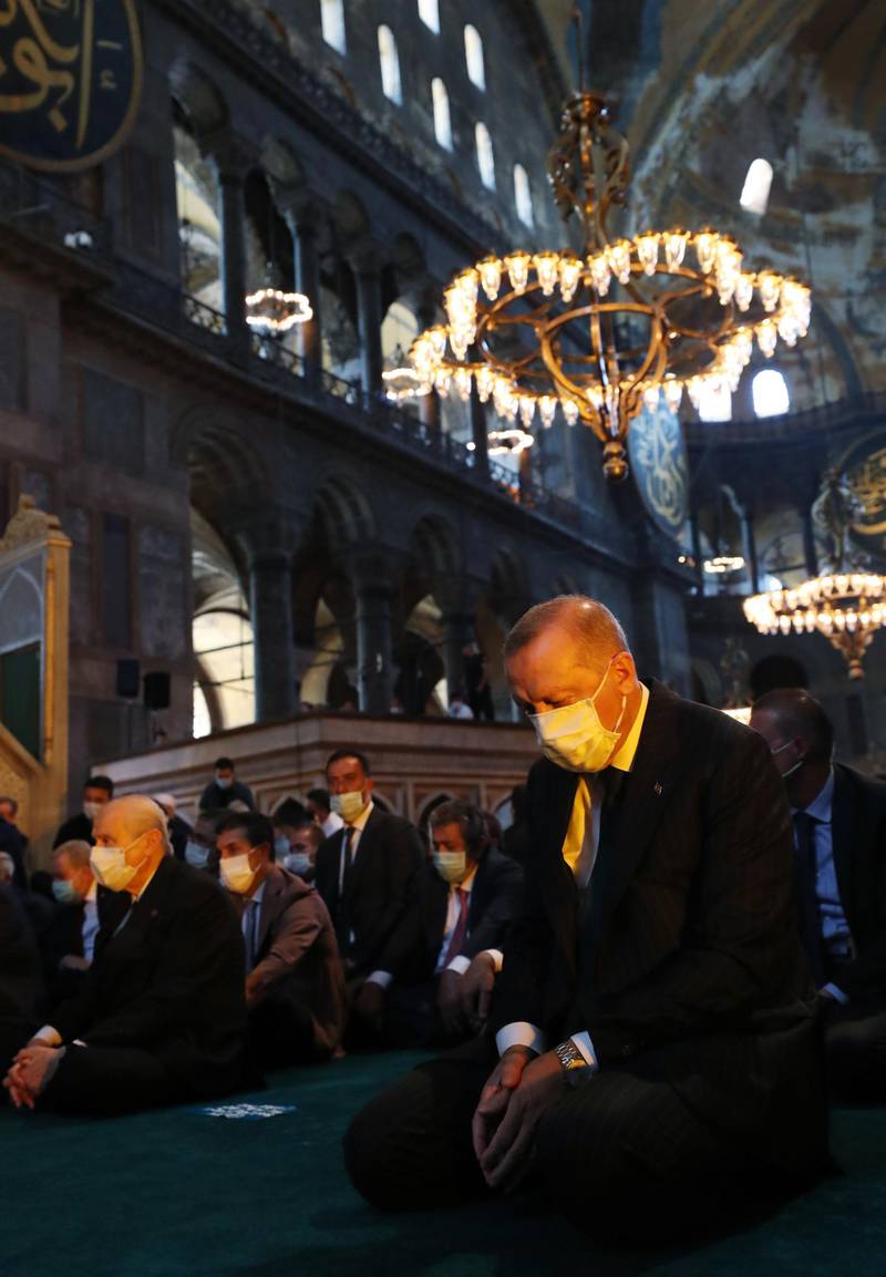 Turkey's President Recep Tayyip Erdogan and invited guests at the Hagia Sophia in Istanbul on July 24, 2020 to attend the 
first Friday prayers there since it was converted back to mosque by his government. Turkish Presidential Service / AFP