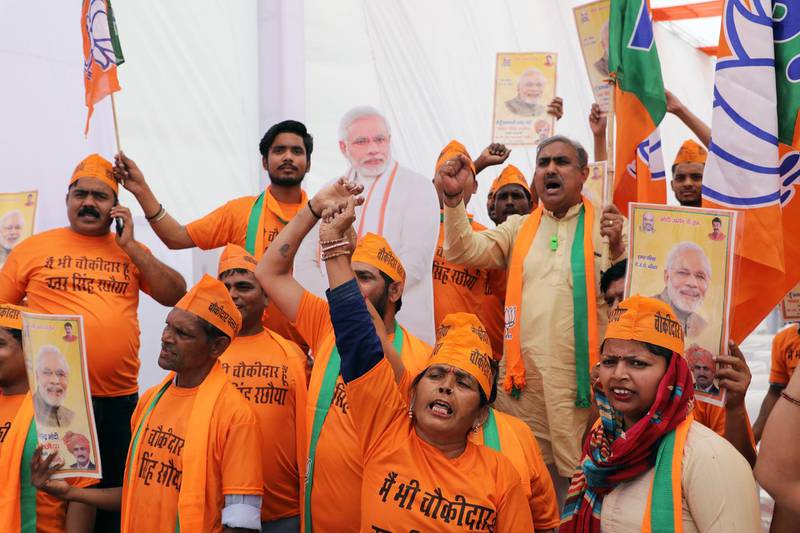 Supporters stand beside a cardboard cut-out of India's Prime Minister Narendra Modi at an event marking the release of the Bharatiya Janata Party manifesto at the party's headquarters in New Delhi, India, on Monday, April 8, 2019. The ruling BJP pledged spend $1.44 trillion on infrastructure to boost the economy and raise living standards, in a bid to match its main rival’s populist promises. Photographer: T. Narayan/Bloomberg