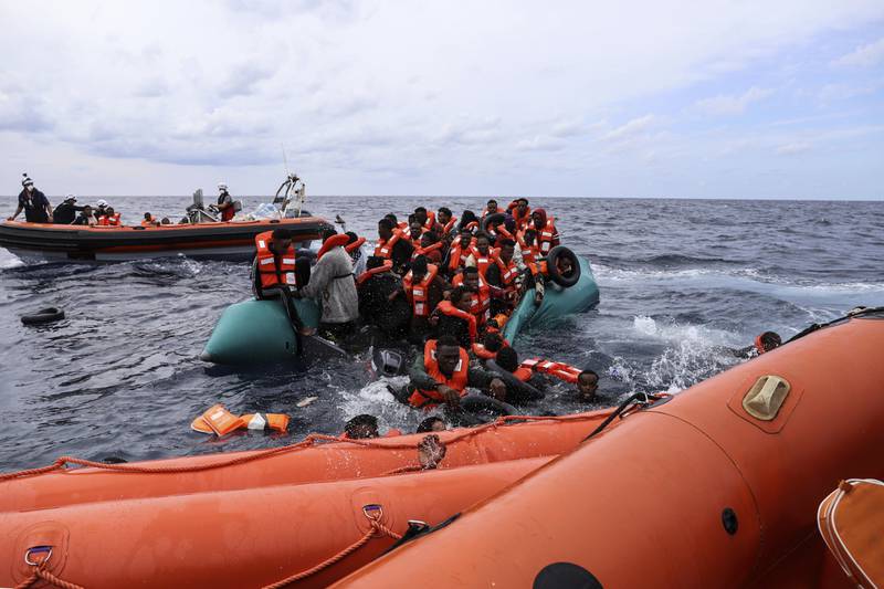 Migrants aboard a rubber boat end up in the water before being rescued by 'Sea Watch-3' crew members, approximately 35 miles from Libya. All photos: AP