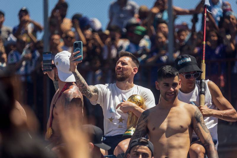 Argentine football star Lionel Messi takes pictures with his phone while celebrating. AFP