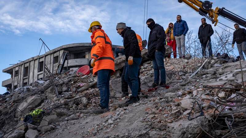 Rescuers search for signs of life at the site of a collapsed building