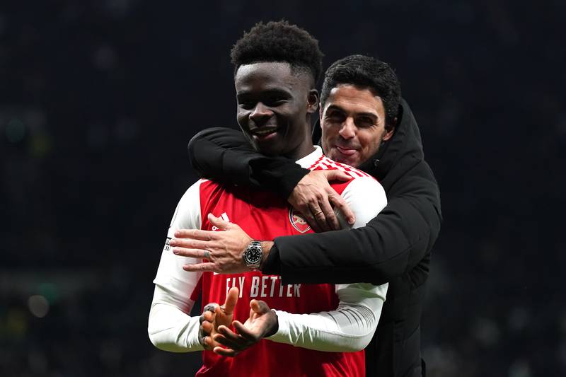 Arsenal's Bukayo Saka celebrates with manager Mikel Arteta. PA