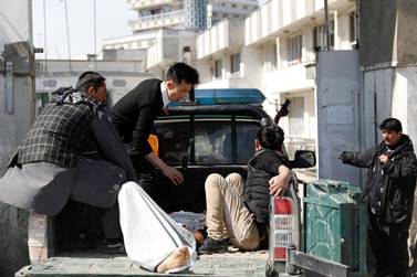 Men carry an injured person to the hospital after attacks in Kabul, Afghanistan. Reuters