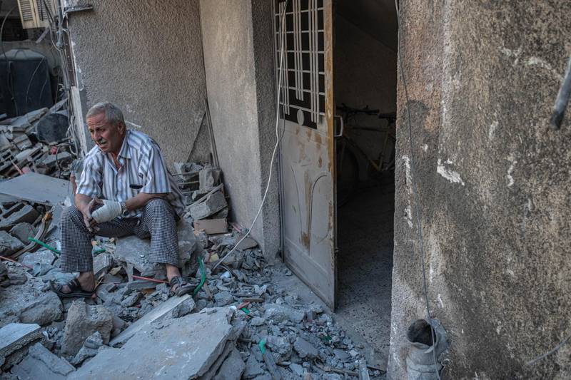 A man inspects damage to a house in al-Shati Refugee Camp west of Gaza City. Getty Images