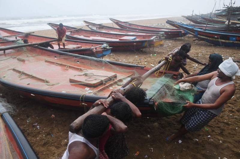 Fishing boats are dragged to safer ground. AFP
