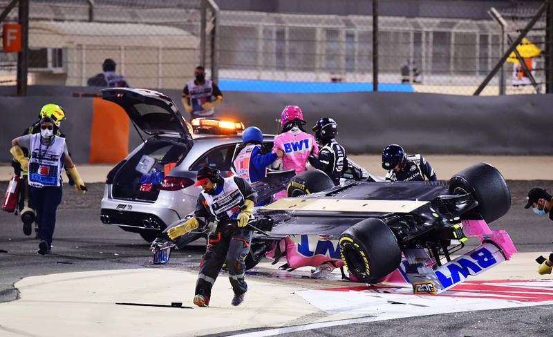Lance Stroll of Racing Point is helped out of his overturned car. Getty