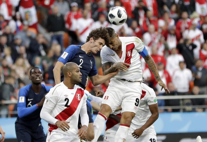 Peru's Paolo Guerrero, right, is airborne with France's Benjamin Pavard. Natacha Pisarenko / AP Photo