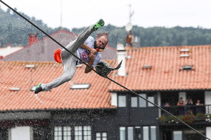 A participant falls into the water after picking up a false goose from a rope during the celebration of the traditional Goose Day local competition in Lekeitio, Vizcaya, Spain. Miguel Tona/EPA