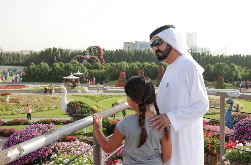 The Ruler of Dubai looks out onto the gardens with his daughter Sheikha Al Jalila.