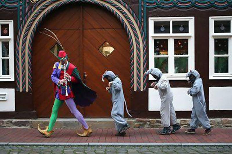 The Pied Piper of Hamelin, actually city tourism employee  leads local children dressed as rats through a quiet German street. Sean Gallup / Getty Images