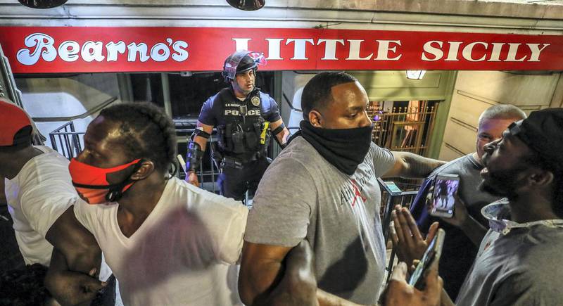 May 28, 2020; Louisville, KY, USA; Protestors surround Louisville Metro Police officer Galen Hinshaw in front of Bearno s restaurant on Thursday, May 28, 2020. Five strangers linked arms to protect Hinshaw. Mandatory Credit: Michael Clevenger/Courier Journal-USA TODAY NETWORK