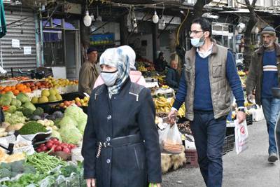 epa08920700 Syrians wearing masks as precautionary measures against the Coronavirus, buy their daily basic food items and other necessities in one of the streets of Damascus, Syria, 05 January 2021.  EPA/YOUSSEF BADAWI