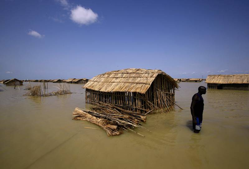 South Sudanese refugees try to repair their hut in flooded waters from the White Nile at a camp inundated after heavy rain in Al Qana, Sudan, in 2021. AFP