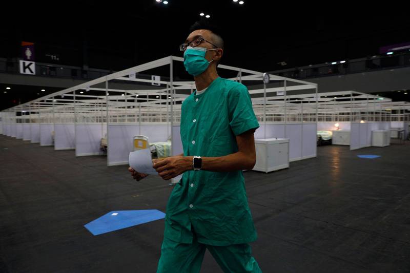 A medical worker makes preparations at a temporary field hospital set up at Asia World Expo in Hong Kong, Saturday, Aug. 1, 2020. The new COVID-19 patient holding facility can accommodate up to 500 adult patients in stable conditions. The facility which is located near the Hong Kong International Airport is a big convention and exhibition facility and was previously used as a coronavirus testing center for incoming travelers. It's transformed into a treatment facility so that it helps freeing up hospital beds for the serious patients. (AP Photo/Kin Cheung)