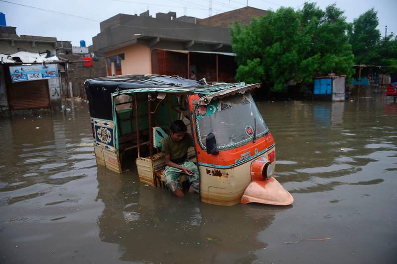 A boy sits in a auto-rickshaw in a flooded area after heavy monsoon rains in Pakistan's port city of Karachi.   AFP