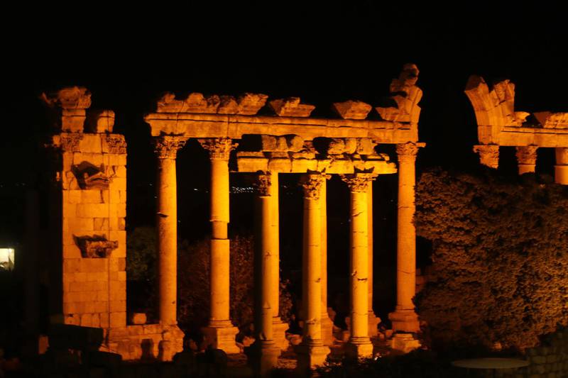 The ruins of the Roman era Heliopolis of Baalbeck is illuminated in orange on the occasion of International Women's Day, in the Lebanese Bekaa Valley.  AFP