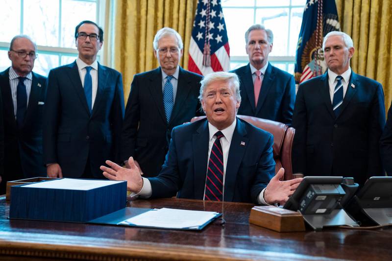 President Donald Trump talks to reporters before signing the coronavirus stimulus relief package in the Oval Office at the White House, Friday, March 27, 2020, in Washington, as White House chief economic adviser Larry Kudlow, Treasury Secretary Steven Mnuchin, Senate Majority Leader Mitch McConnell, R-Ky., House Minority Leader Kevin McCarty, R-Calif., and Vice President Mike Pence look on. (AP Photo/Evan Vucci)