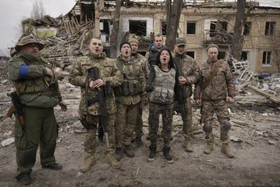 Ukrainian servicemen sing a patriotic song amid buildings destroyed during fighting between Ukrainian and Russian forces in Borodyanka on April 5. AP