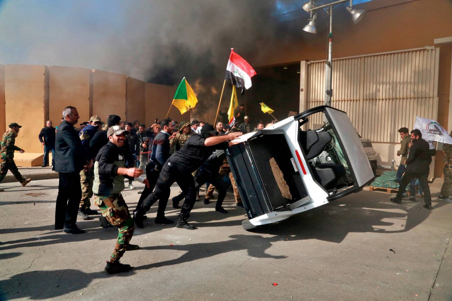 FILE - In this Dec 31, 2019  file photo, pro-Iranian militiamen and their supporters damage property inside the U.S. embassy compound, in Baghdad, Iraq. The Trump administration has signaled it could close its diplomatic mission in Baghdad if measures are not taken to control rogue armed elements responsible for a recent spate of attacks against U.S. and other interests in the country, Iraqi and U.S. officials said Monday, Sept. 28, 2020. (AP Photo/Khalid Mohammed, File)