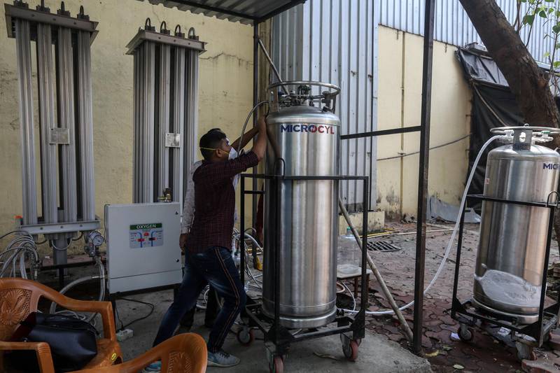 An Indian worker stands near oxygen cylinders at a jumbo Covid-19 centre in Mumbai. EPA