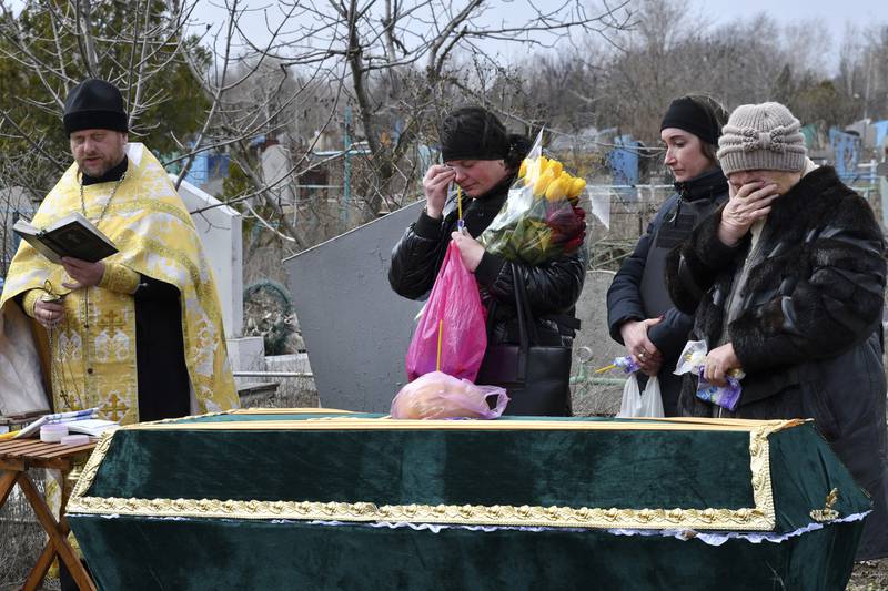 Relatives and friends are overwhelmed with emotions as they stand next to the coffin of Anatoly German during his funeral. AP