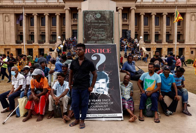 Demonstrators watch a public screen as voting begins in Sri Lanka's Parliament. Reuters