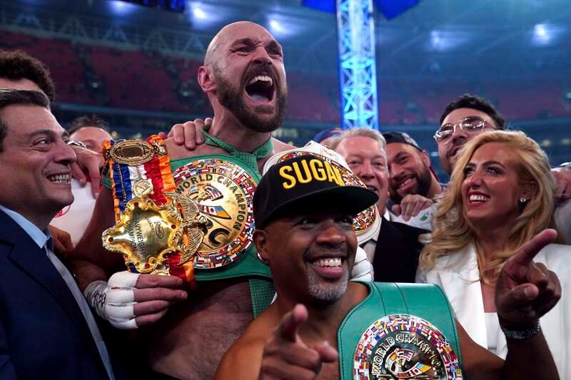 Tyson Fury celebrates with his wife Paris, right, and trainer SugarHill Steward. AP