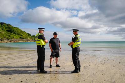 Police officers patrol on the beach in front of the Carbis Bay Hotel. Getty Images
