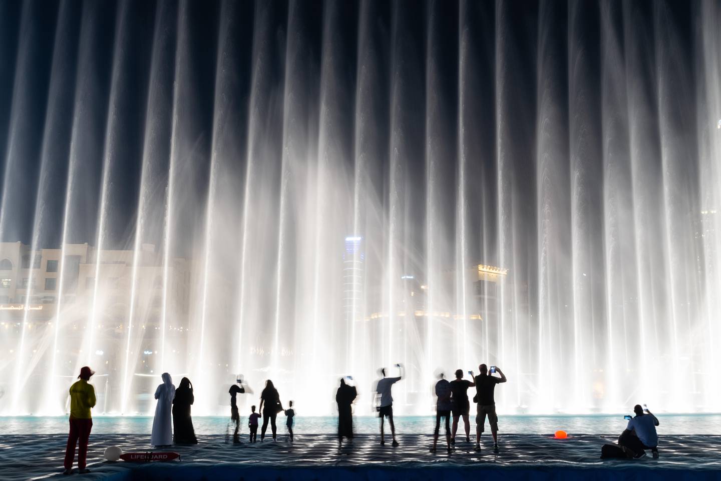 People enjoying the fountain show in Dubai at night. Alamy